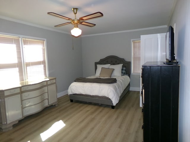 bedroom featuring light wood-style floors, ceiling fan, baseboards, and crown molding