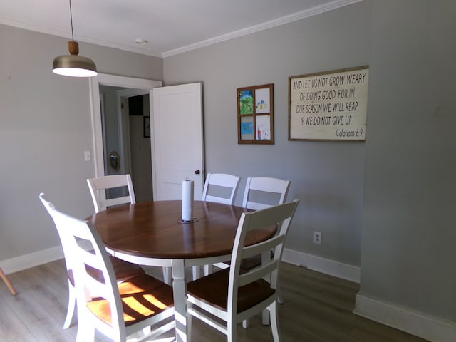 dining area featuring ornamental molding, baseboards, and wood finished floors