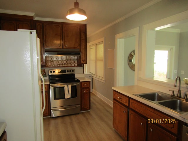 kitchen with electric range, ornamental molding, freestanding refrigerator, under cabinet range hood, and a sink