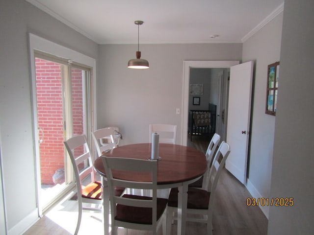 dining area featuring light wood-style floors and crown molding