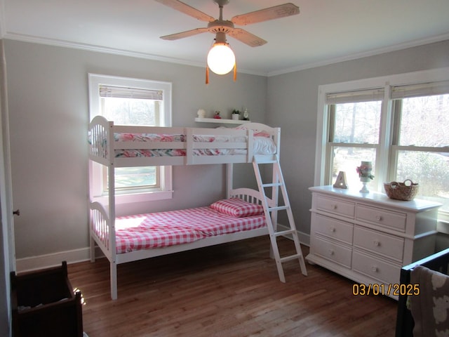 bedroom featuring ornamental molding, baseboards, and wood finished floors