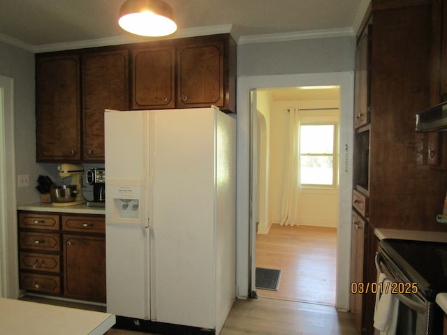 kitchen featuring white fridge with ice dispenser, light countertops, visible vents, and crown molding