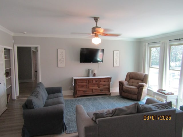 living area with a ceiling fan, baseboards, ornamental molding, and wood finished floors