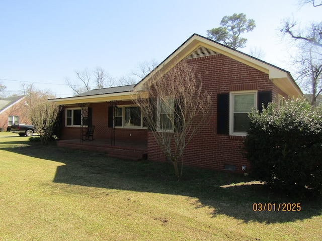 view of side of property featuring crawl space, brick siding, and a lawn