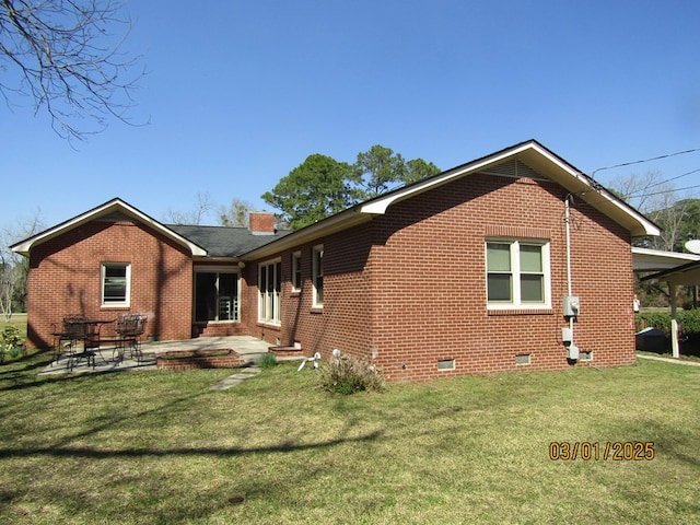 back of house with a patio, brick siding, crawl space, a lawn, and a chimney