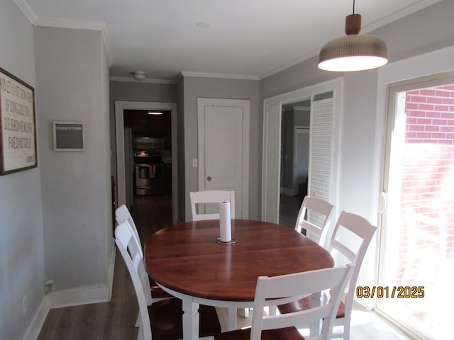 dining space featuring crown molding, baseboards, and wood finished floors