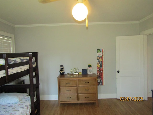 bedroom featuring crown molding, dark wood finished floors, and baseboards