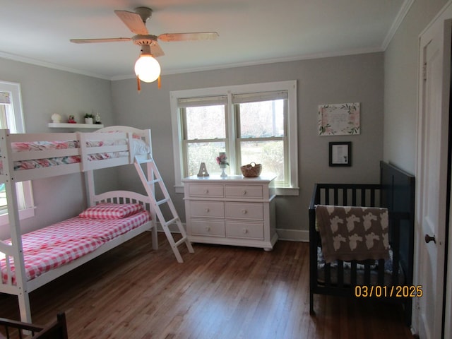 bedroom with baseboards, ceiling fan, wood finished floors, and crown molding