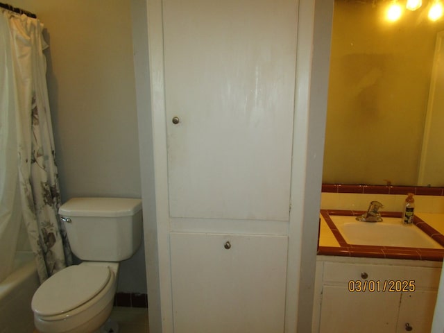 bathroom featuring toilet, shower / bath combination with curtain, and vanity