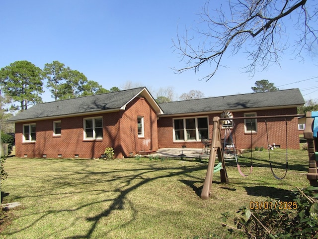 rear view of house with a yard, crawl space, brick siding, and a patio