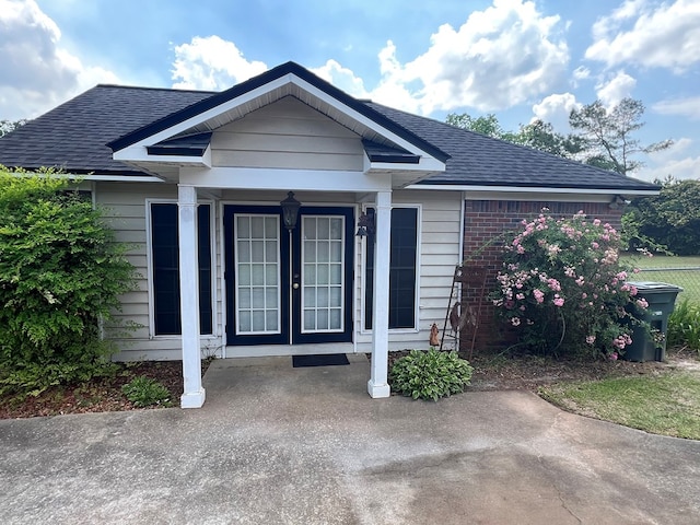 view of front of home with a shingled roof and french doors