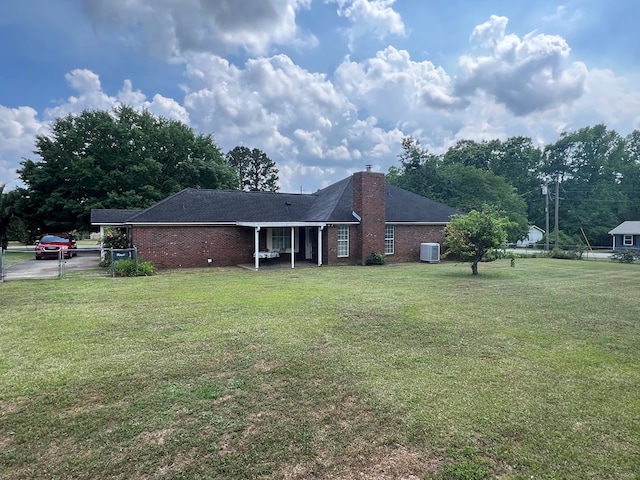 view of front of property featuring a chimney, brick siding, central air condition unit, and a front yard