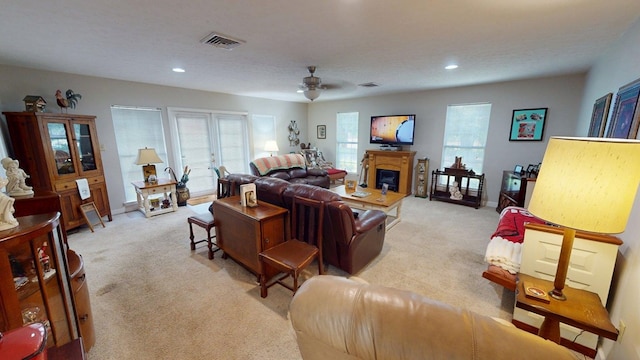 living room featuring a ceiling fan, visible vents, light carpet, and recessed lighting