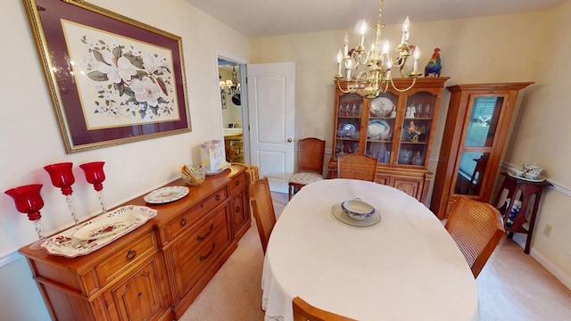 dining room with baseboards, light carpet, and a chandelier