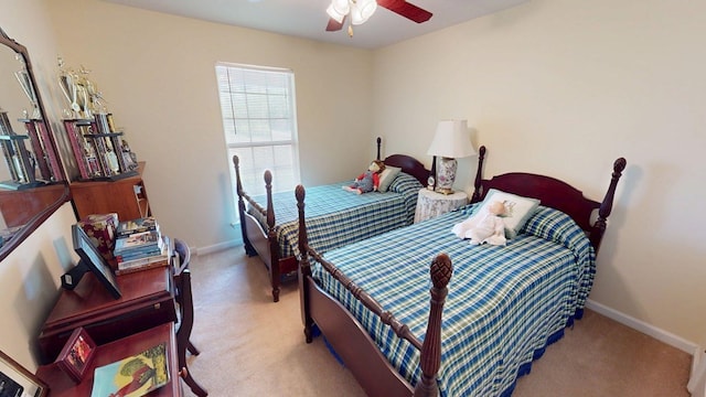 bedroom with a ceiling fan, baseboards, and light carpet