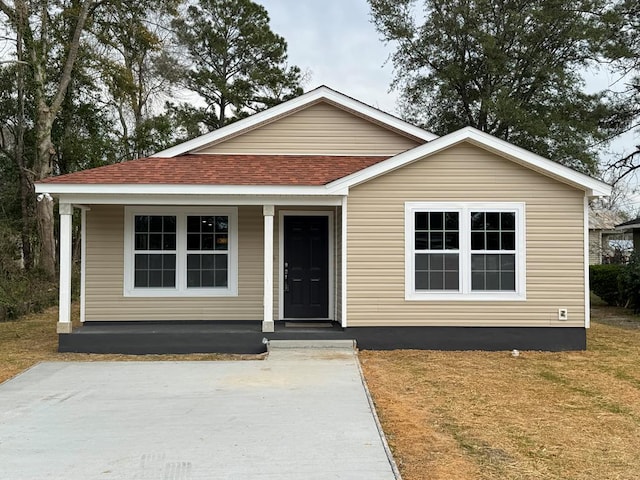 view of front of property featuring covered porch and a shingled roof