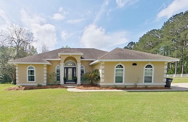 102 SE Mimosa Dr, Cairo, GA 39828 - mediterranean / spanish-style home featuring fence, a front lawn, a shingled roof, and stucco siding