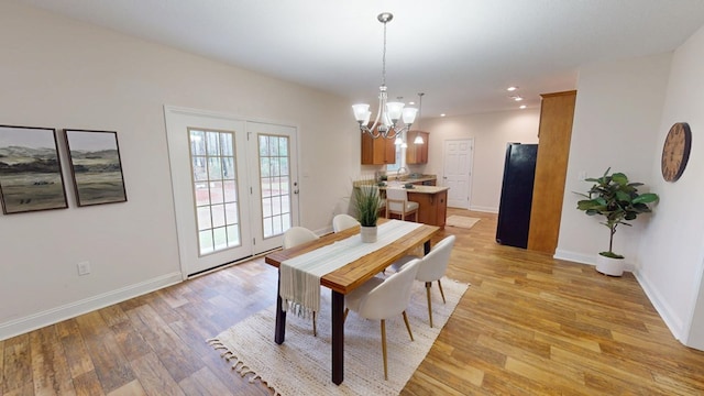 dining area featuring light wood finished floors, a chandelier, recessed lighting, and baseboards