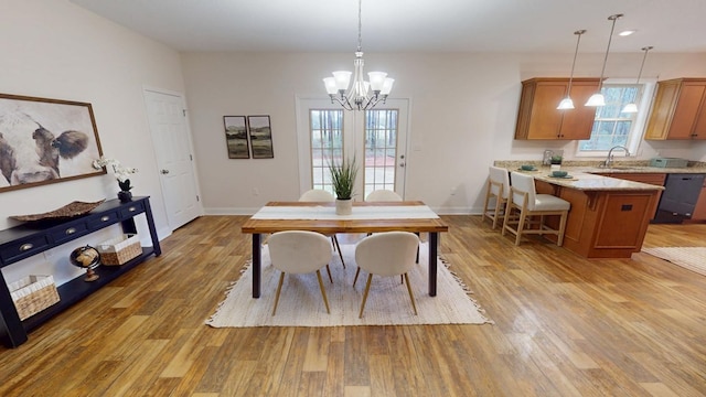 dining space with an inviting chandelier, baseboards, and light wood finished floors