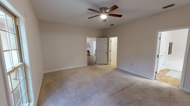 unfurnished bedroom featuring ensuite bathroom, baseboards, visible vents, and carpet floors