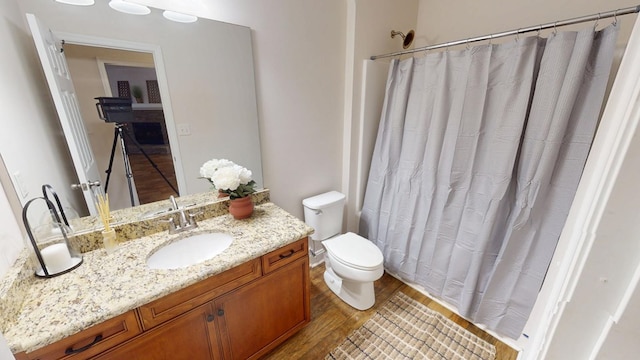 full bathroom featuring vanity, a shower with curtain, toilet, and wood finished floors