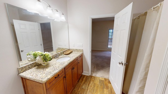 full bath featuring vanity, baseboards, and wood finished floors