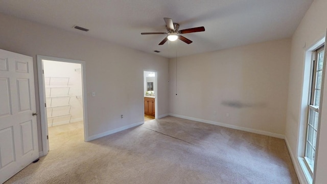 spare room with visible vents, baseboards, light colored carpet, and a ceiling fan