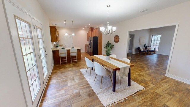 dining space featuring visible vents, baseboards, light wood-style floors, and a chandelier