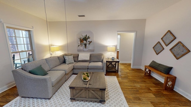 living room featuring visible vents, baseboards, and wood finished floors