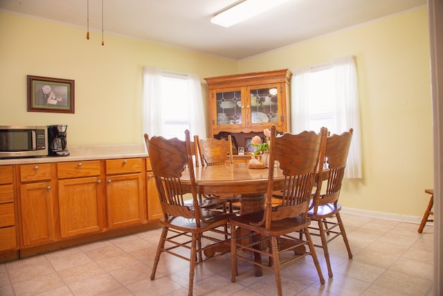 dining area with crown molding and light floors