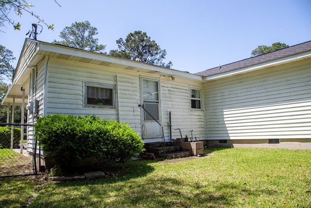 exterior space featuring entry steps, crawl space, fence, and a lawn