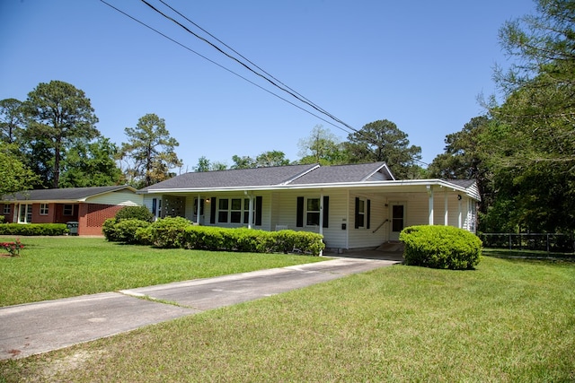view of front of home featuring concrete driveway, an attached carport, and a front lawn