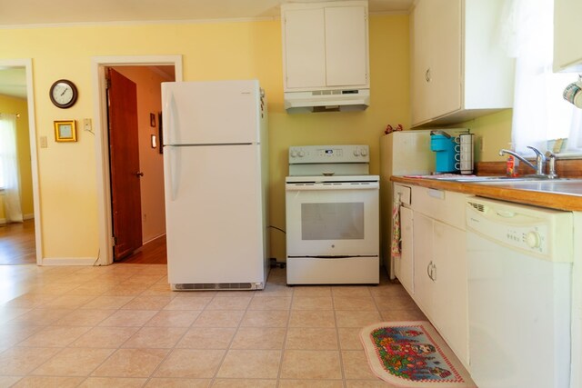 kitchen with white appliances, white cabinetry, under cabinet range hood, light countertops, and a sink