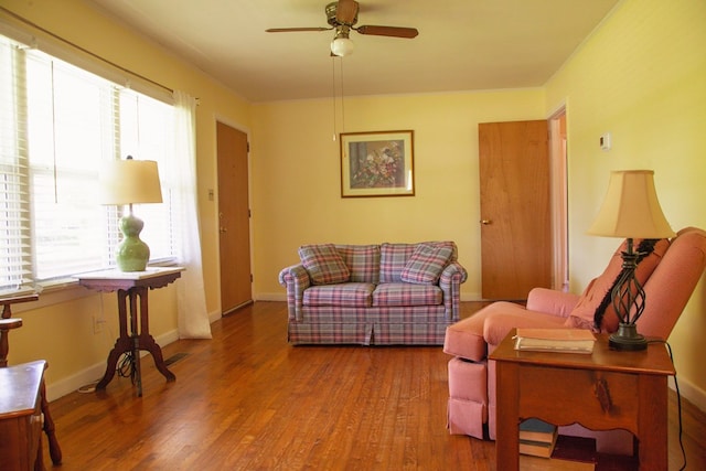 living room with wood finished floors, ceiling fan, and baseboards