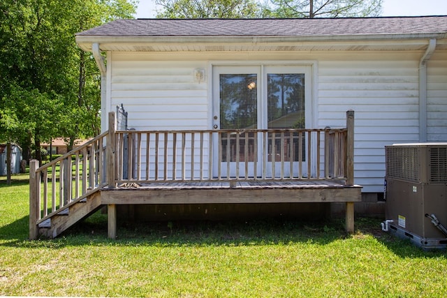 wooden terrace featuring a lawn and central air condition unit