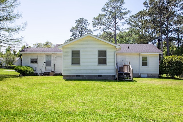 back of property featuring a yard, crawl space, and roof with shingles