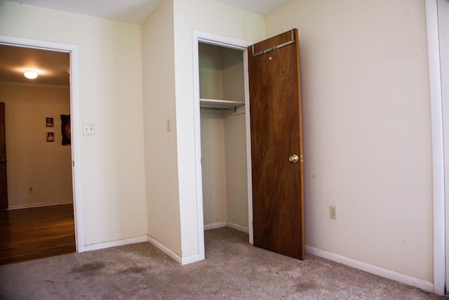 unfurnished bedroom with a closet, carpet flooring, and baseboards