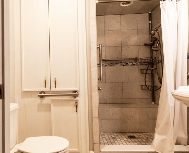 bathroom featuring toilet and a stall shower