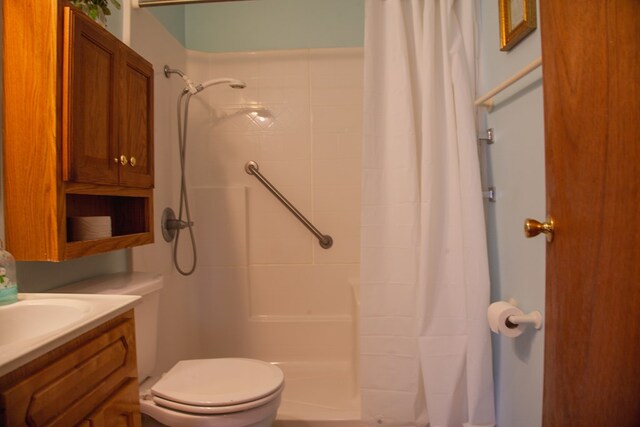 bathroom with toilet, vanity, and a shower with curtain