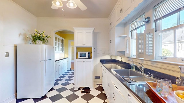 kitchen with white cabinetry, sink, white appliances, and ornamental molding