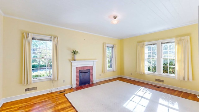 living room with crown molding, hardwood / wood-style flooring, and a fireplace