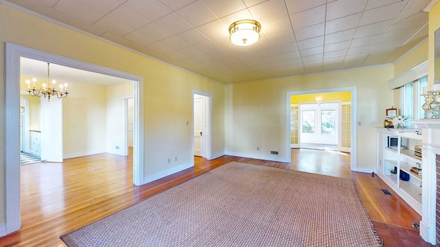 living room featuring crown molding, light hardwood / wood-style floors, and a notable chandelier