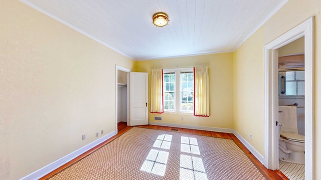 unfurnished bedroom with ornamental molding and hardwood / wood-style floors