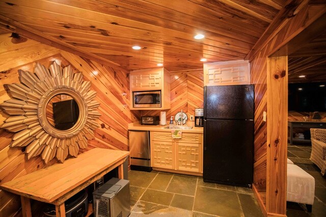 kitchen with wooden ceiling, black refrigerator, stainless steel microwave, wooden walls, and dishwashing machine