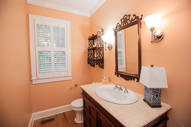 bathroom with vanity, wood-type flooring, ornamental molding, and toilet