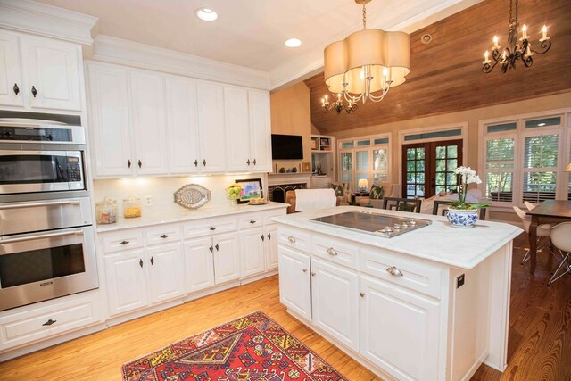 kitchen featuring decorative light fixtures, a chandelier, white cabinets, and appliances with stainless steel finishes