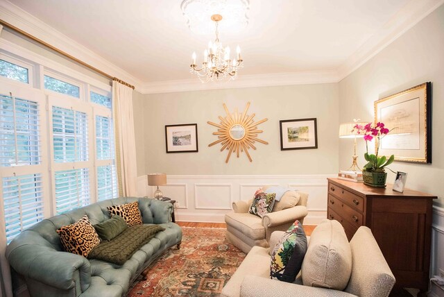 living room with hardwood / wood-style flooring, crown molding, and an inviting chandelier