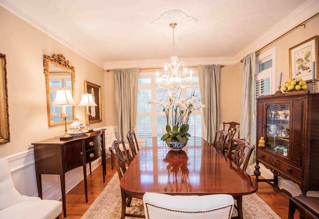 dining space featuring an inviting chandelier, crown molding, and wood-type flooring