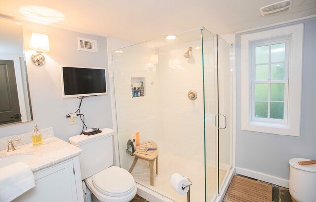 bathroom featuring toilet, vanity, and walk in shower