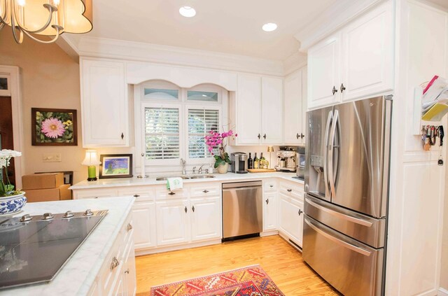 kitchen with crown molding, stainless steel appliances, light hardwood / wood-style flooring, and white cabinets